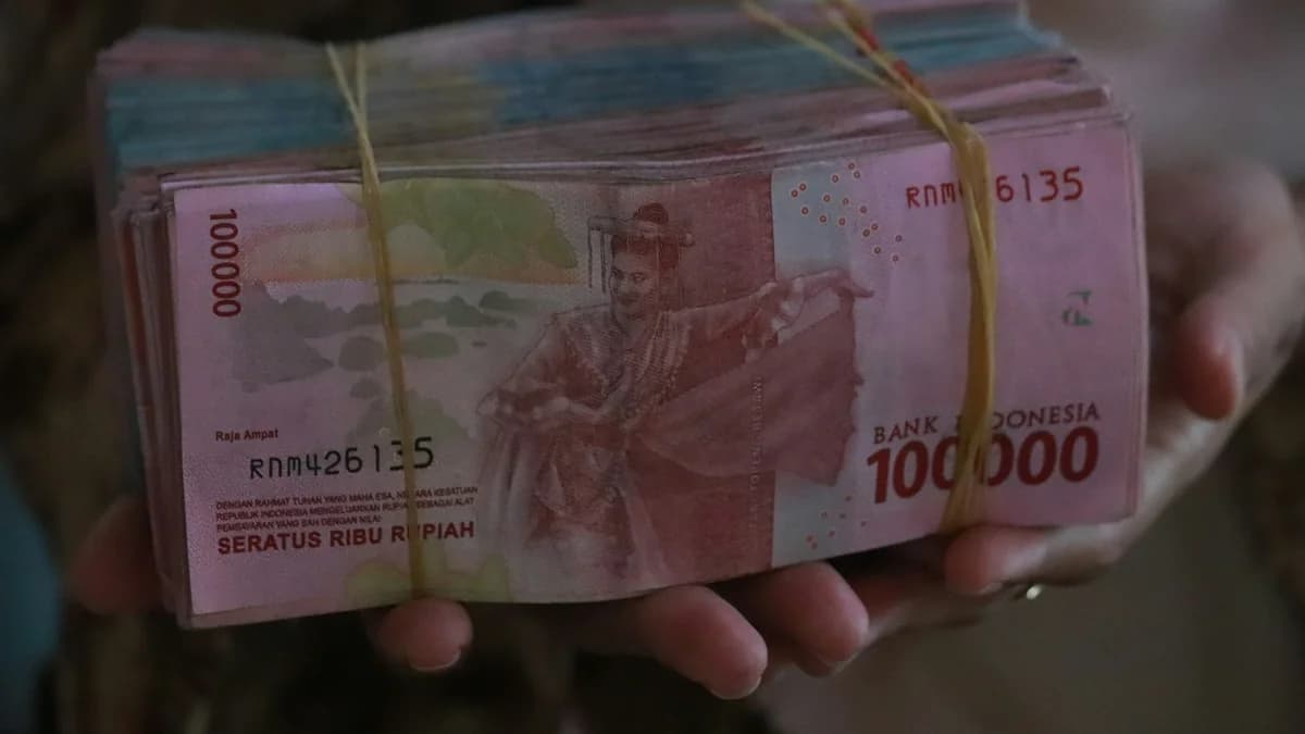 Ilustrasi uang rupiah dalam genggaman